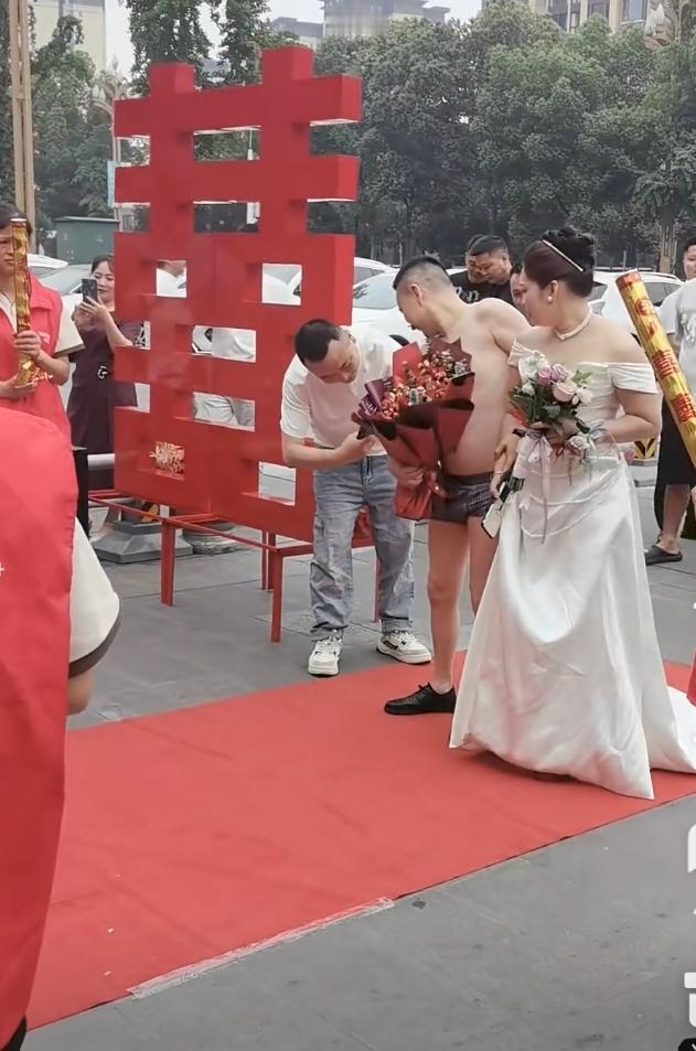 婚礼现场，新郎只穿裤衩走红地毯。
不知道他是不是想表达被新娘一家榨干了，还是什么