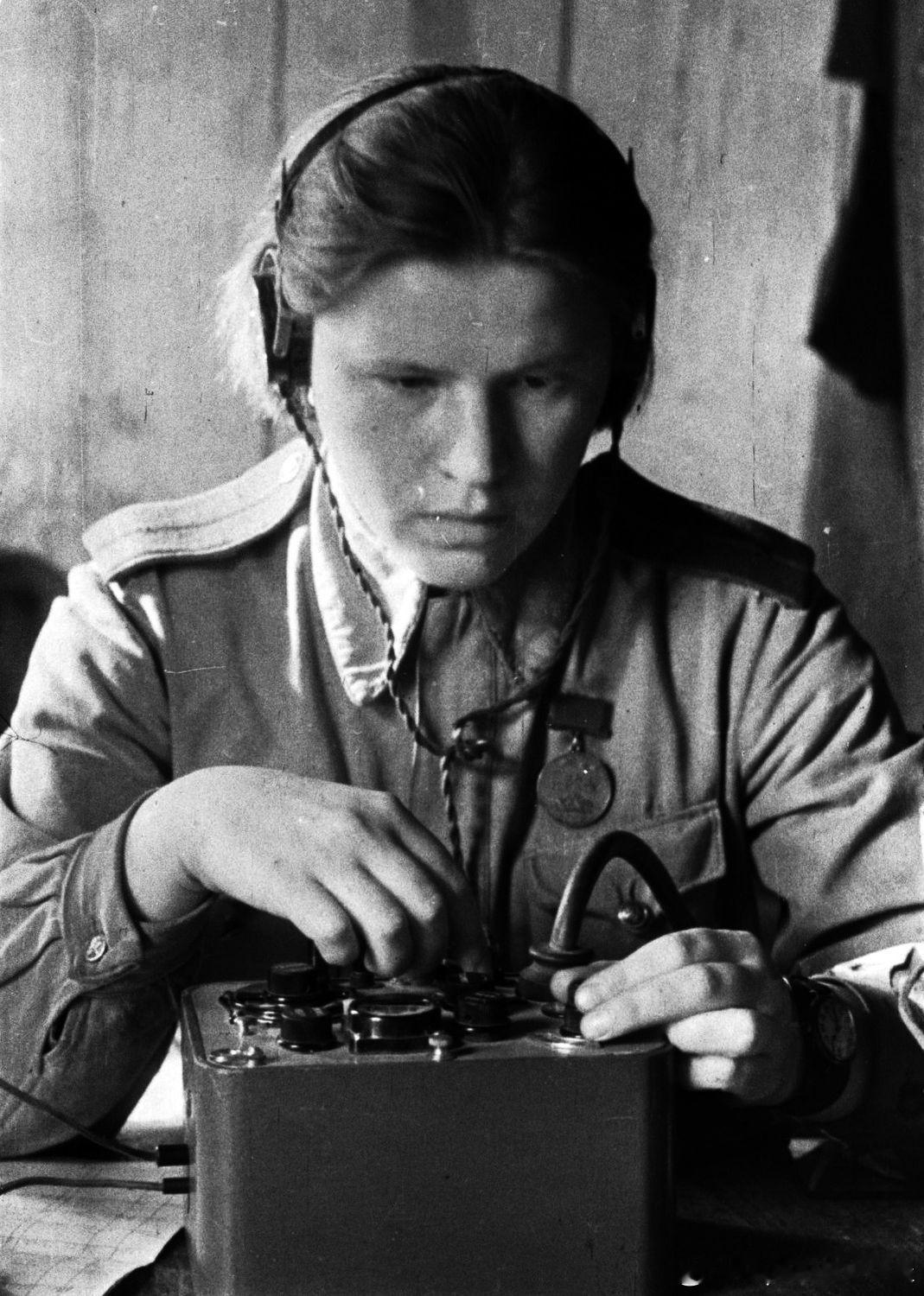 1943年加里宁方面军一名女军人（戴着英勇奖章）正在调谐Север便携式短波电台