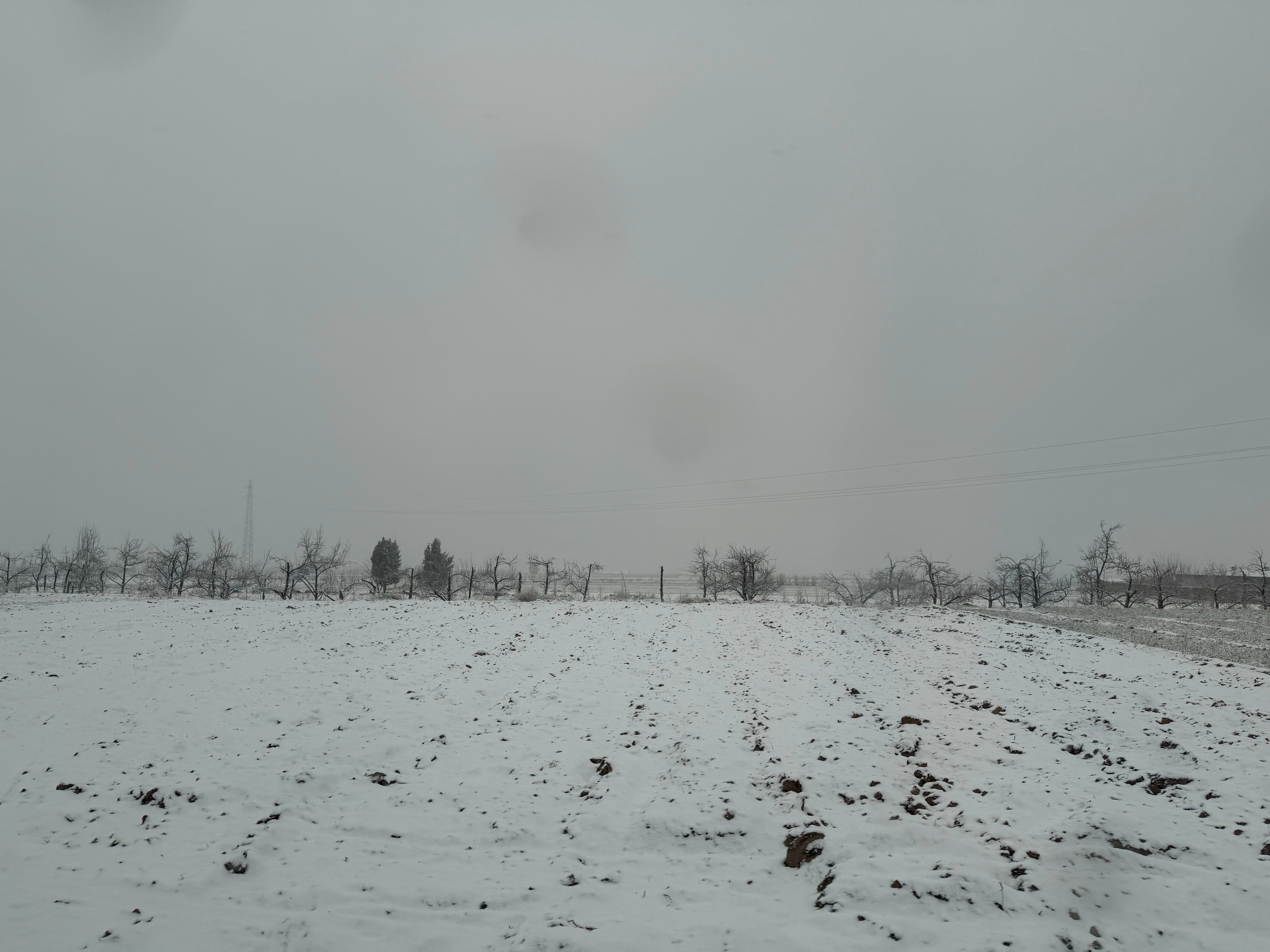 临汾突降大雪从陶寺遗址出来路过黄土坡上的村庄乡间小路也能点亮小蓝灯两侧的田地已经