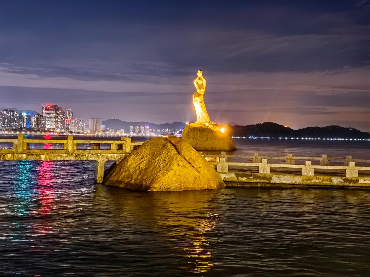 珠海的夜景融合了海滨风光与城市灯火，海滩上的美女雕塑叫“珠海渔女”，是珠海的城市