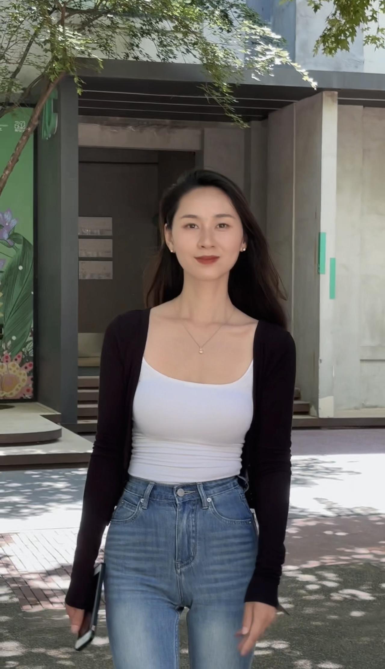 穿白色背心和牛仔裤的女士。