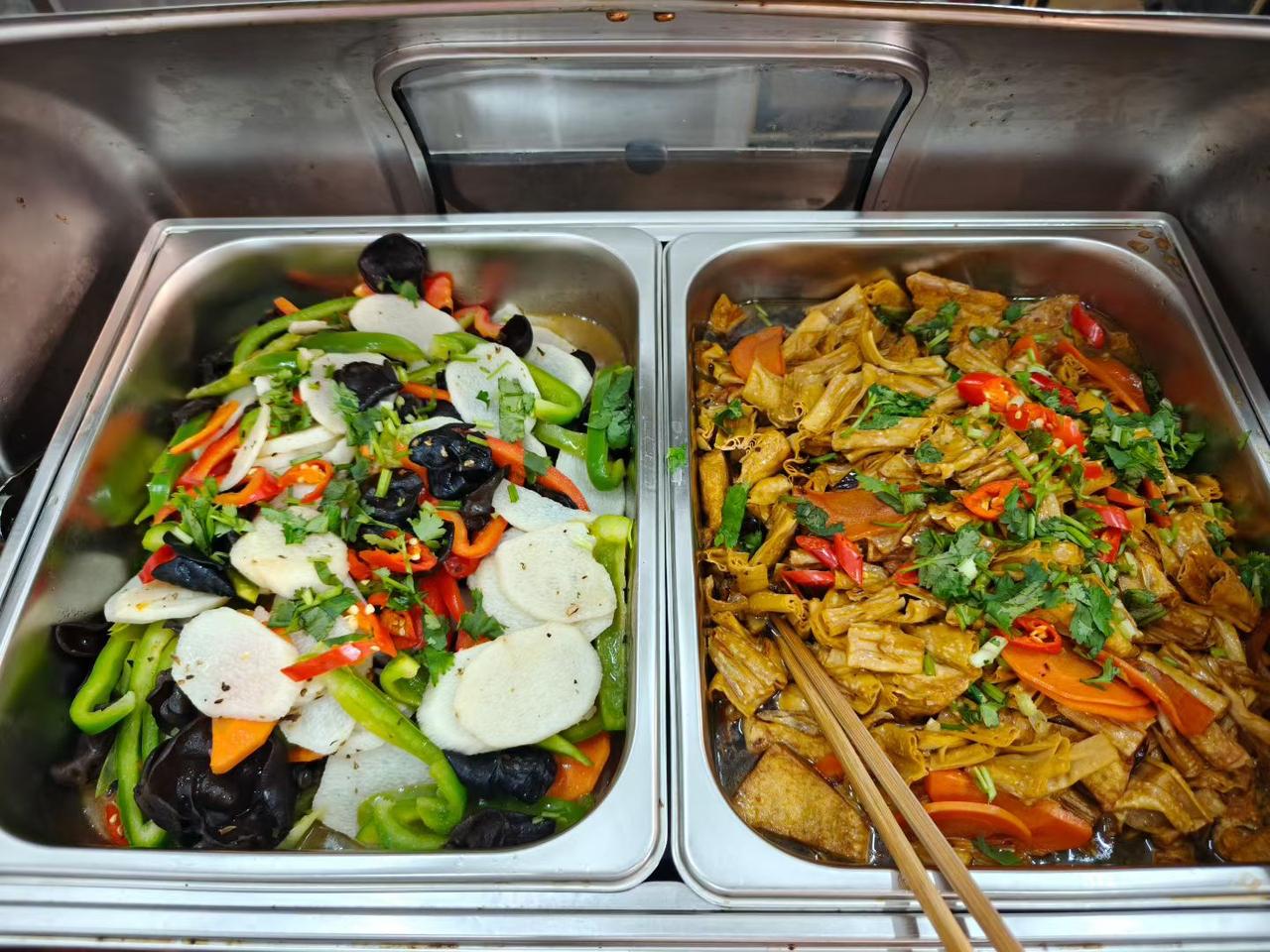 自助餐里，新鲜蔬菜和热菜摆满台，方便客人挑选。