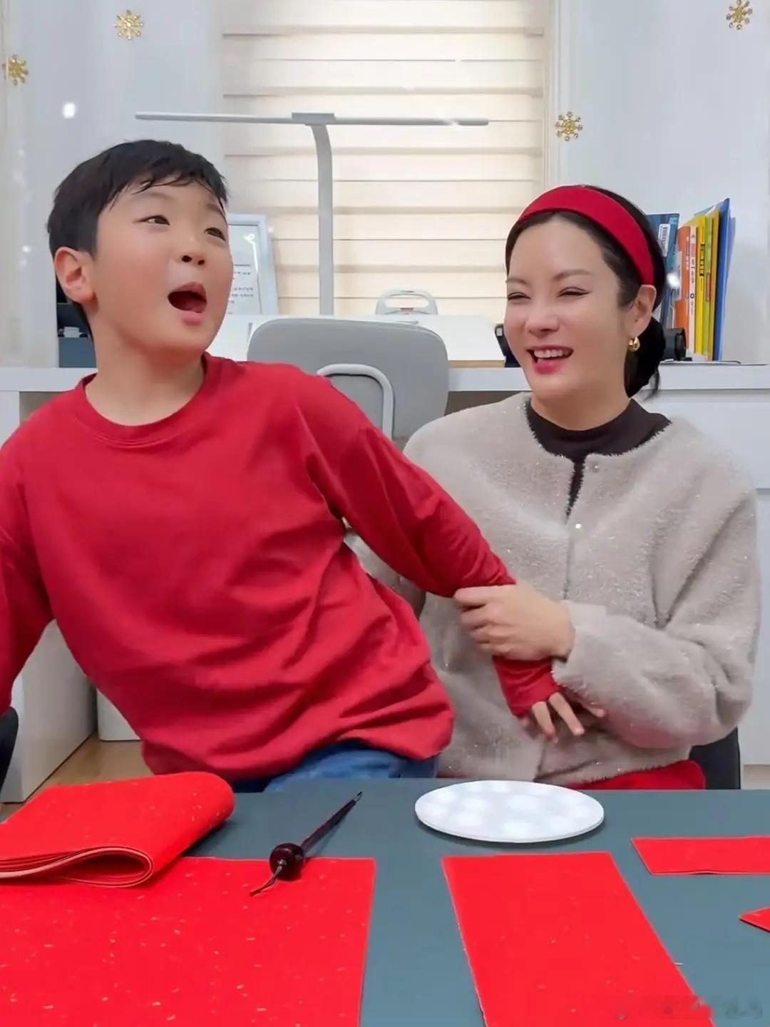 韩星蔡琳教儿子在家里写汉字春联，母子俩长得好像，他脸蛋都圆圆的，脸部好饱满，性格