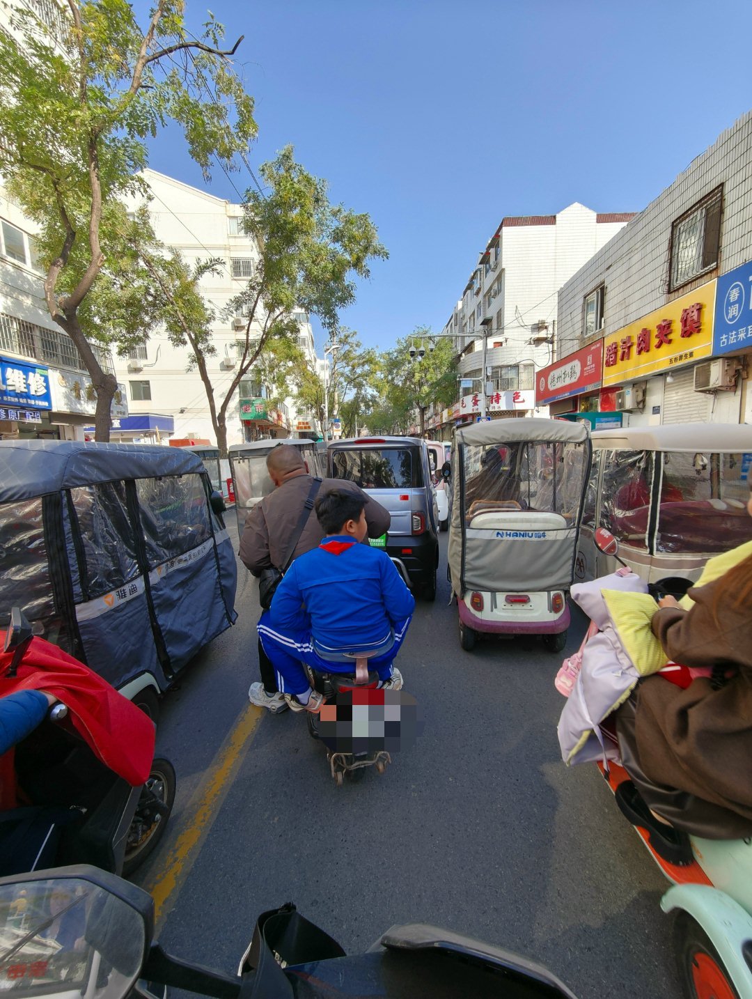 走着走着路就堵死了。满满的都是老年代步车。抄道走到最前面，是一个三轮改的棚车，一