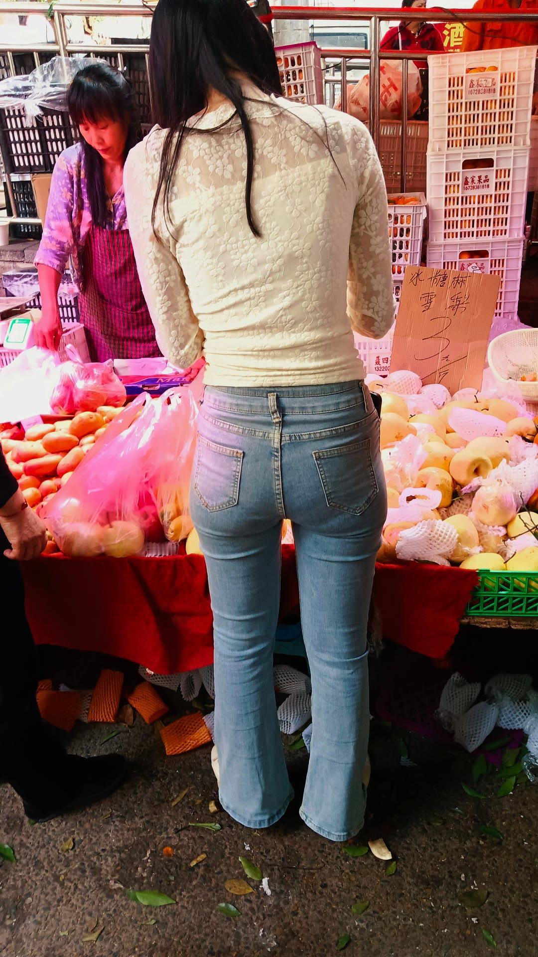 市场里，一位女士正在挑选水果。