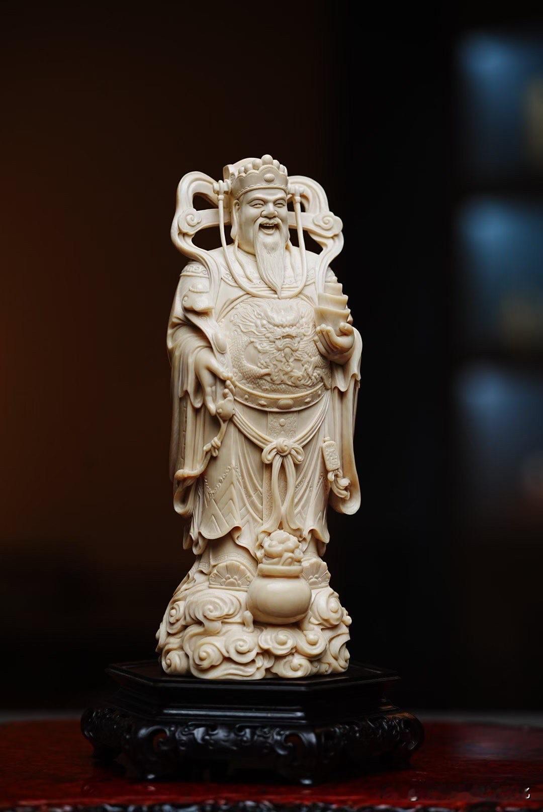 祥云托起财神，衣袂随势舒展，整尊造像静中有动。

须眉细刻，眉眼沉稳，如意与元宝