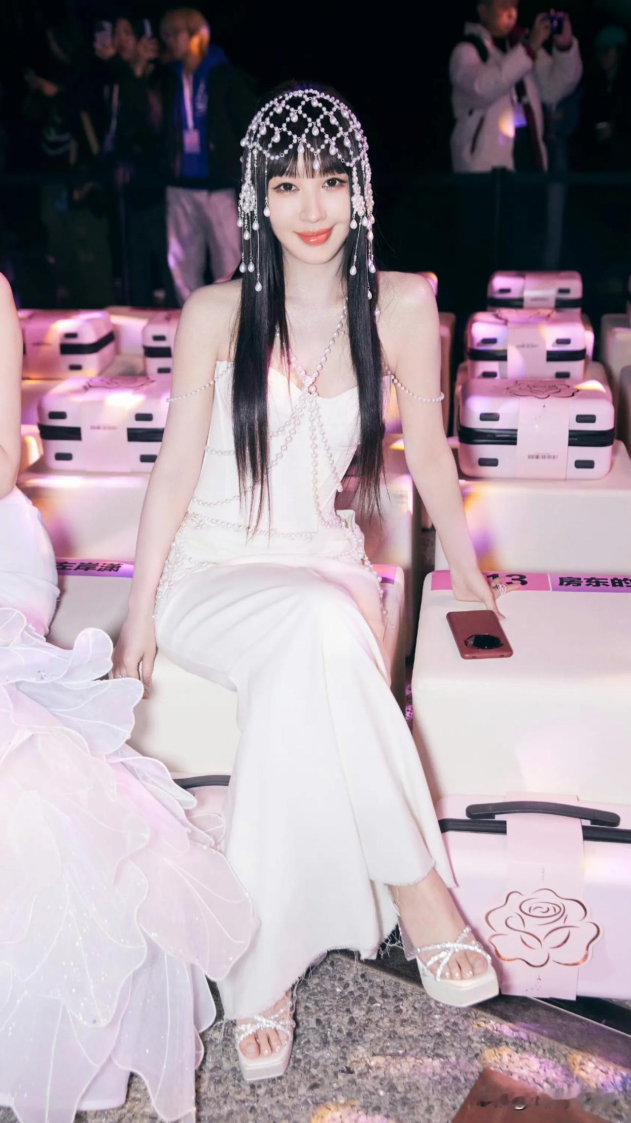 美人倚着花丛，笑语声中暗含清香。李菲儿