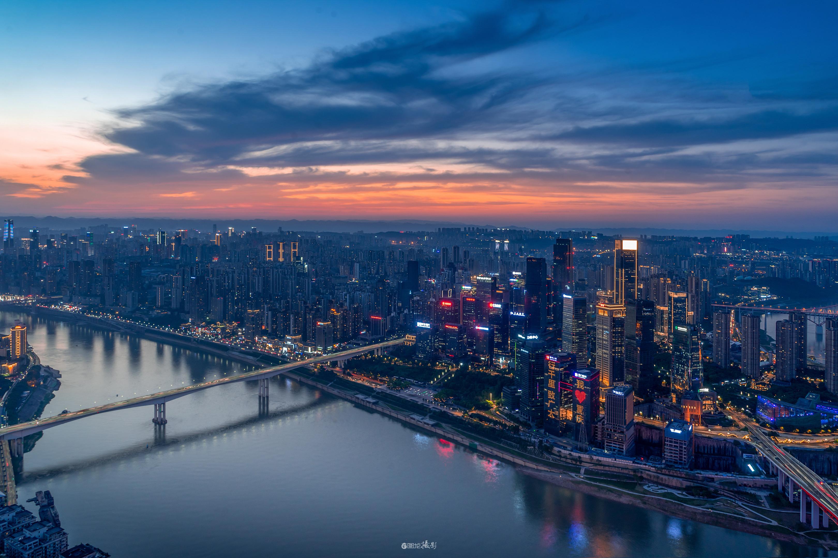 这里是重庆。江波把天的橙与楼的光揉成软的镜，桥的棱嵌在城的暖里，云絮裹...