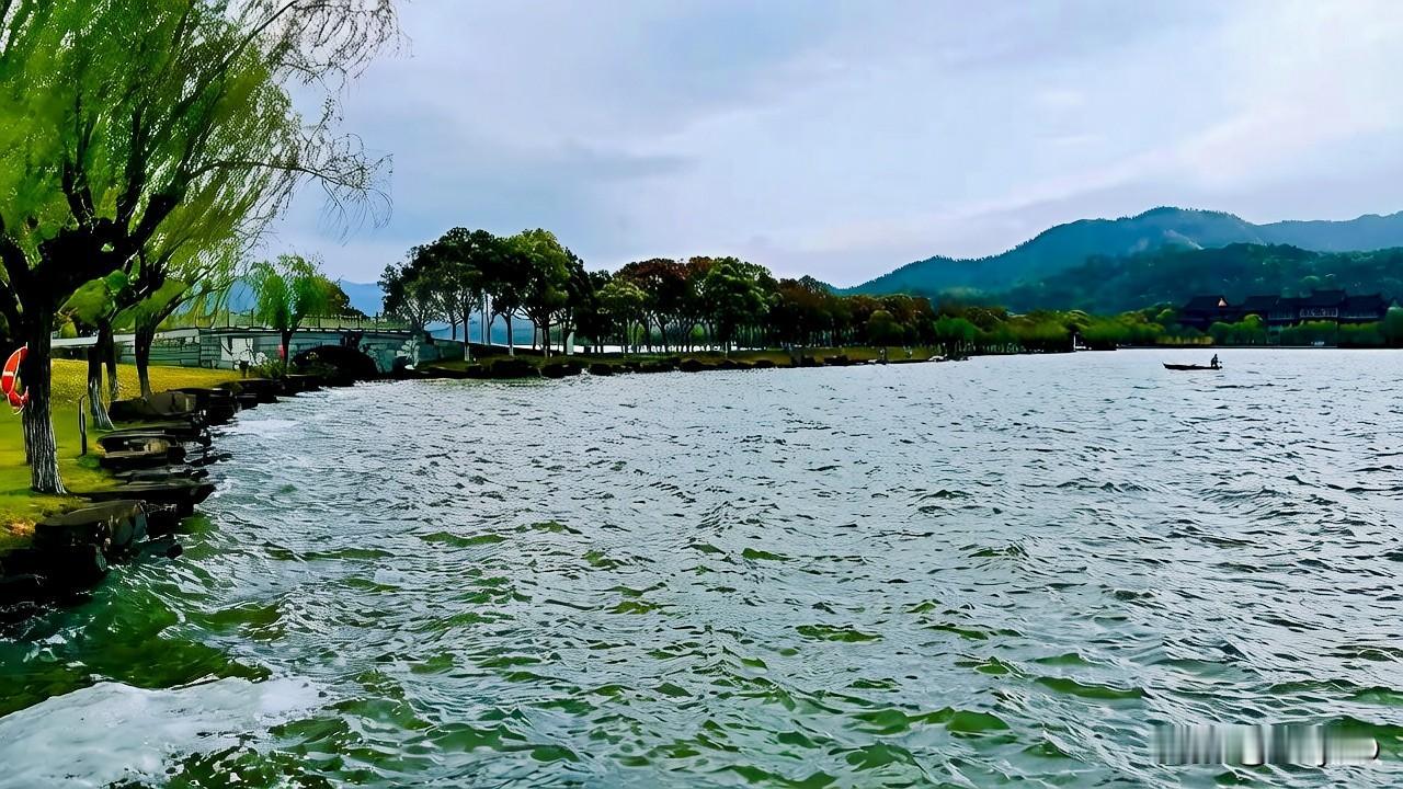 东钱湖湖水漾着清透碧波，远山含黛、云影悠然。湖心半岛古建错落，黑瓦飞檐隐于青葱林