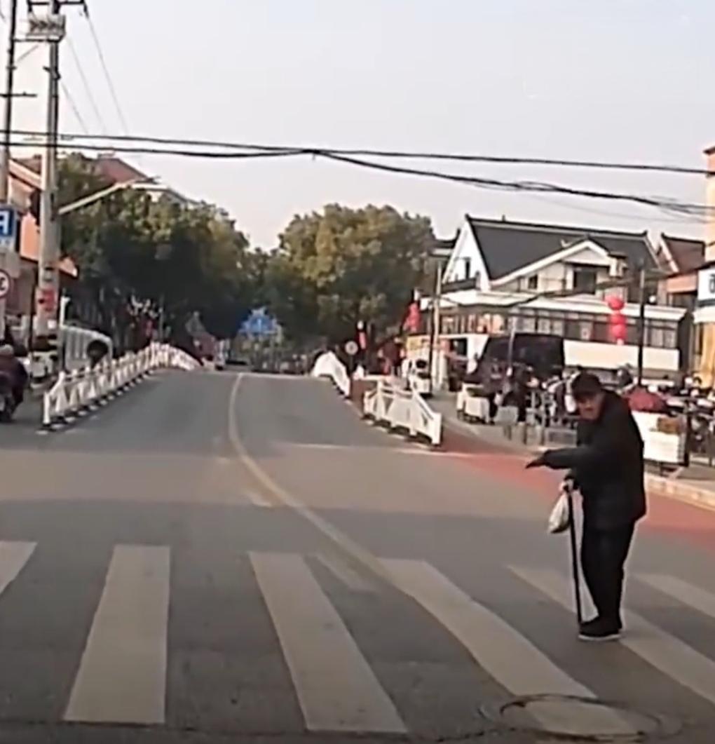 三月的风还带着凉意，路口没有红绿灯。

老爷爷站在斑马线一头，身子往前探了探，又