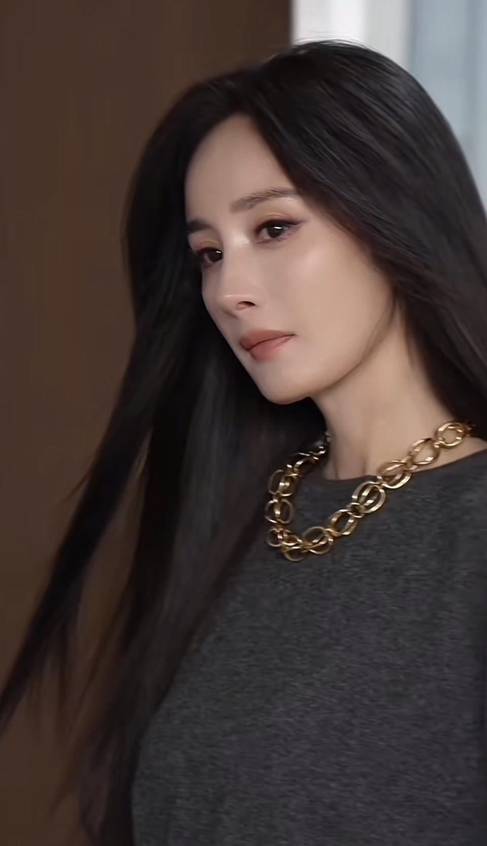 长发美女佩戴金色项链，侧脸温柔。
