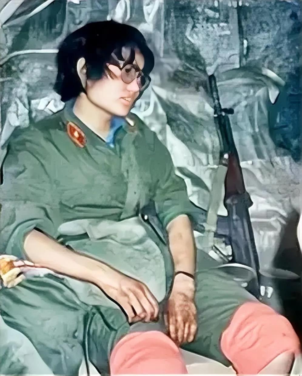 这是一张1986年老山前线的照片，记录了一名女兵刘亚玲完成对伤员的救治后，疲惫倒