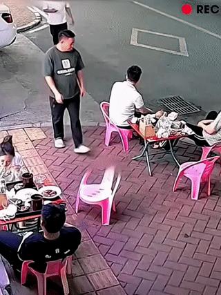 戴眼镜的白衣男子一声不吭，突然偷偷拿走别人的凳子？
这导致正要坐下来的黑衣男子直