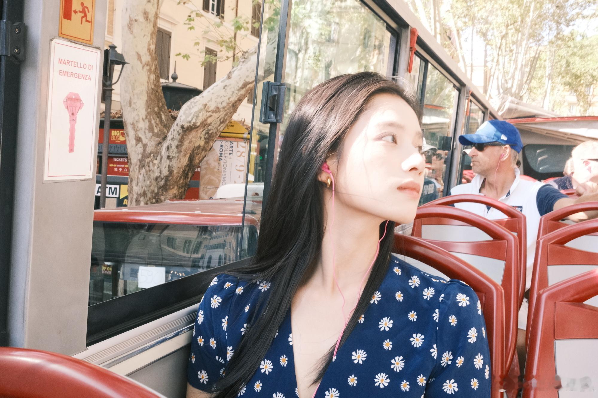 张婧仪身穿蓝色碎花裙，耳戴粉色耳机，这个青春感谁懂啊！又是被姐姐的笑感染到的一天
