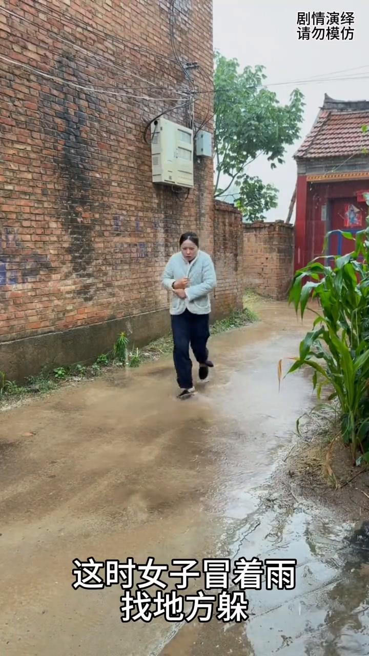 女子下雨天将伞放在衣服里，这一幕真的太有才了。
天空突然下雨了，这时女子冒着雨找