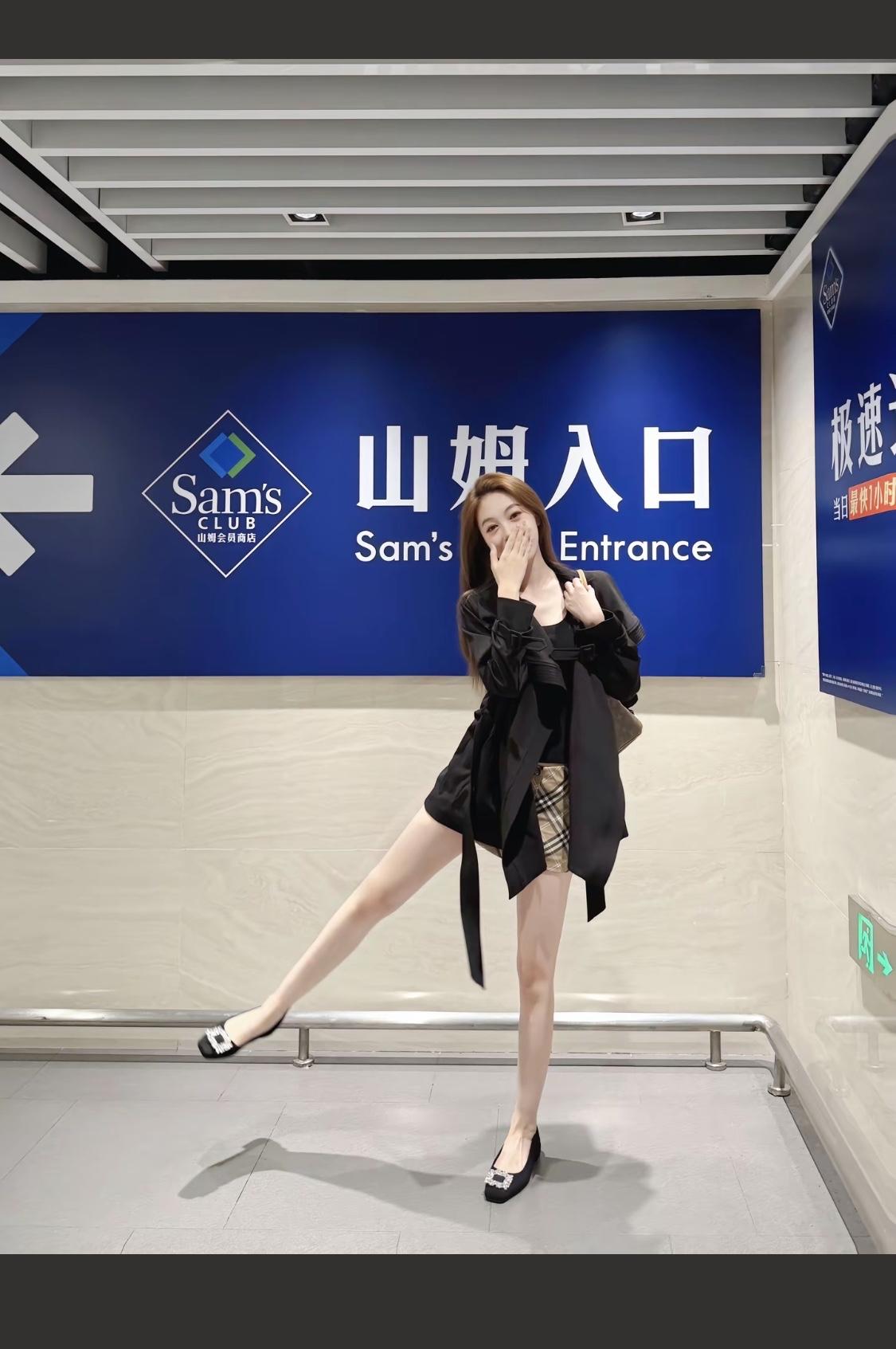 优雅黑衣配格裙，手提包显精致，自信走在自动扶梯上！