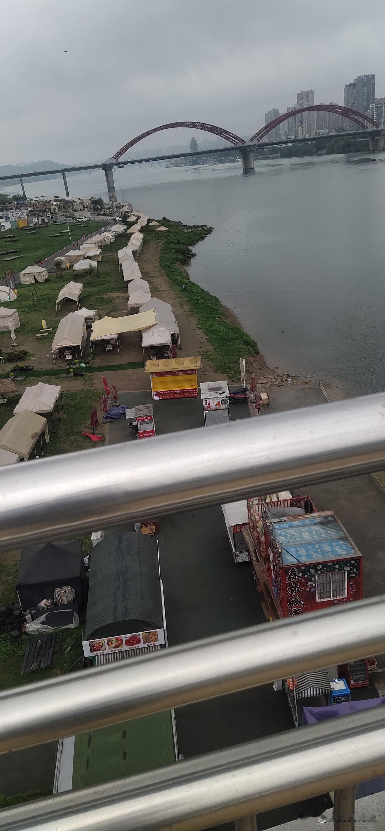 今天去江边溜达，站在高处俯瞰露营区，那场面太壮观了。帐篷一个挨着一个，像彩色的蘑