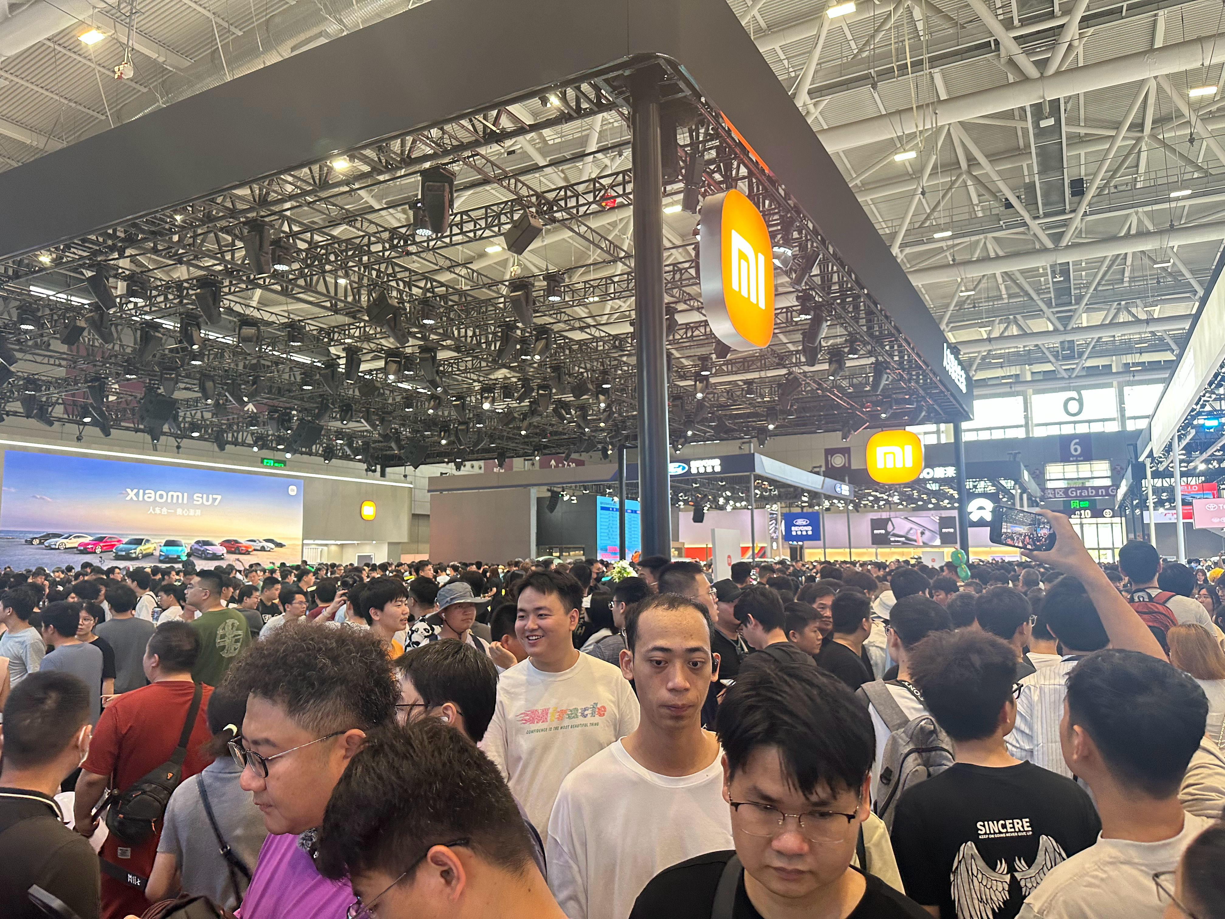 小米展台太火了，排队从室内排到室外，进去看个车估计都要排队一个小时左右，这你受得