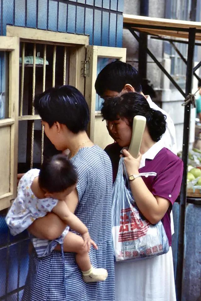 这张照片拍摄于1992年，可以看到大家都集中在街边打电话，那时候没有手机，主演通