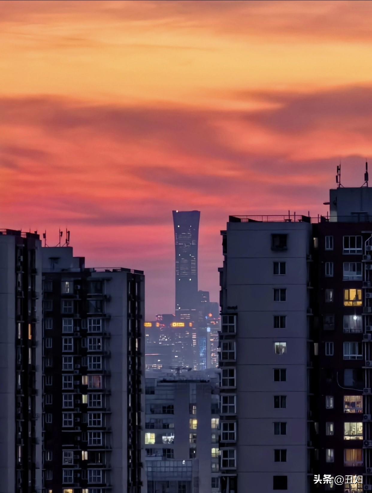 城市黄昏，高楼林立，霓虹初上，繁华都市的静谧与喧嚣交织。