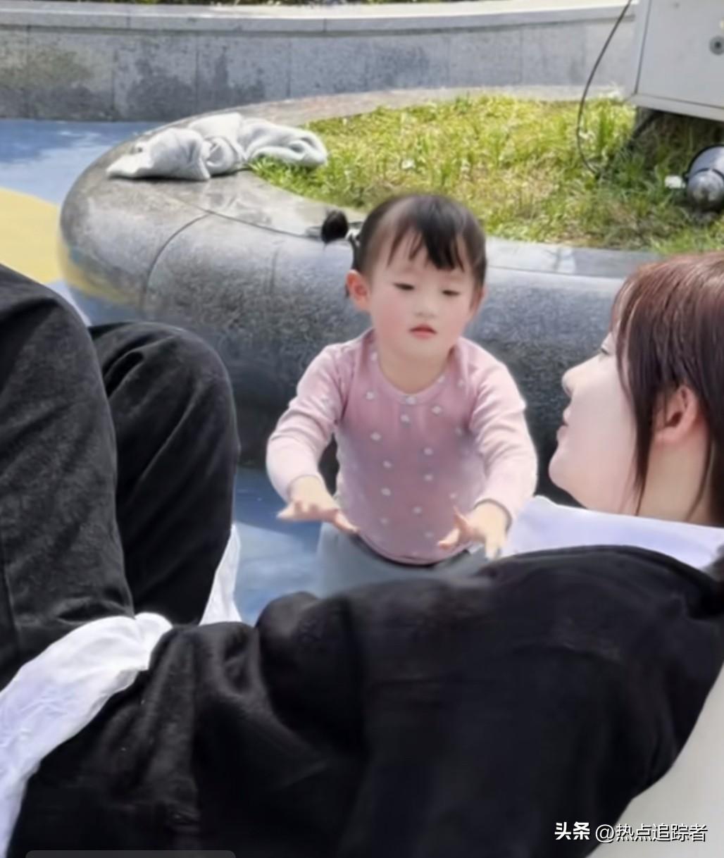 今天下午，黄一鸣发布了一条新视频。画面中，她惬意地躺在千秋上，女儿闪闪在一旁轻轻