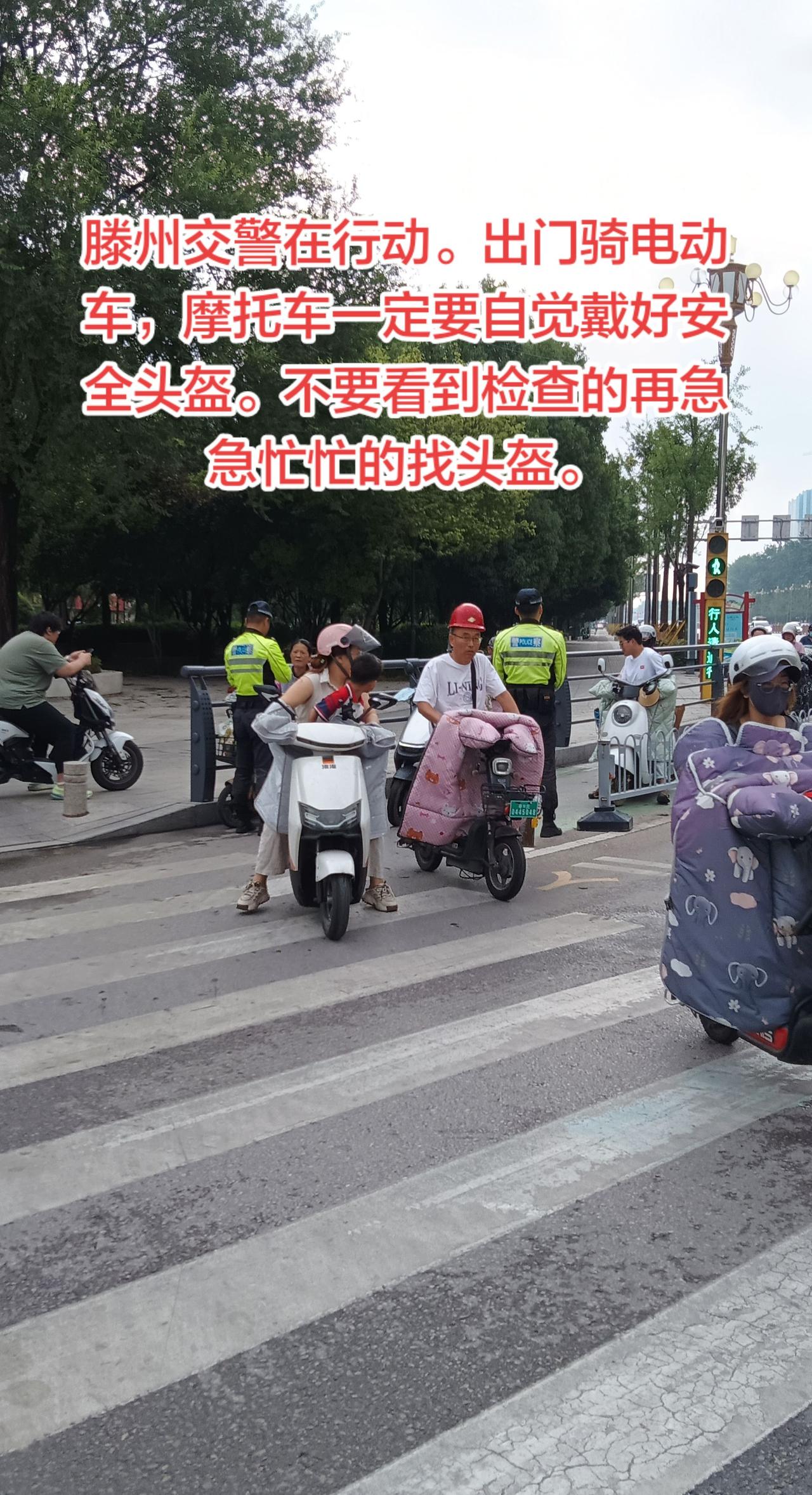 滕州交警在行动。督促骑电动车戴安全头盔。天气慢慢热了，许多人在马路上骑电动车，摩
