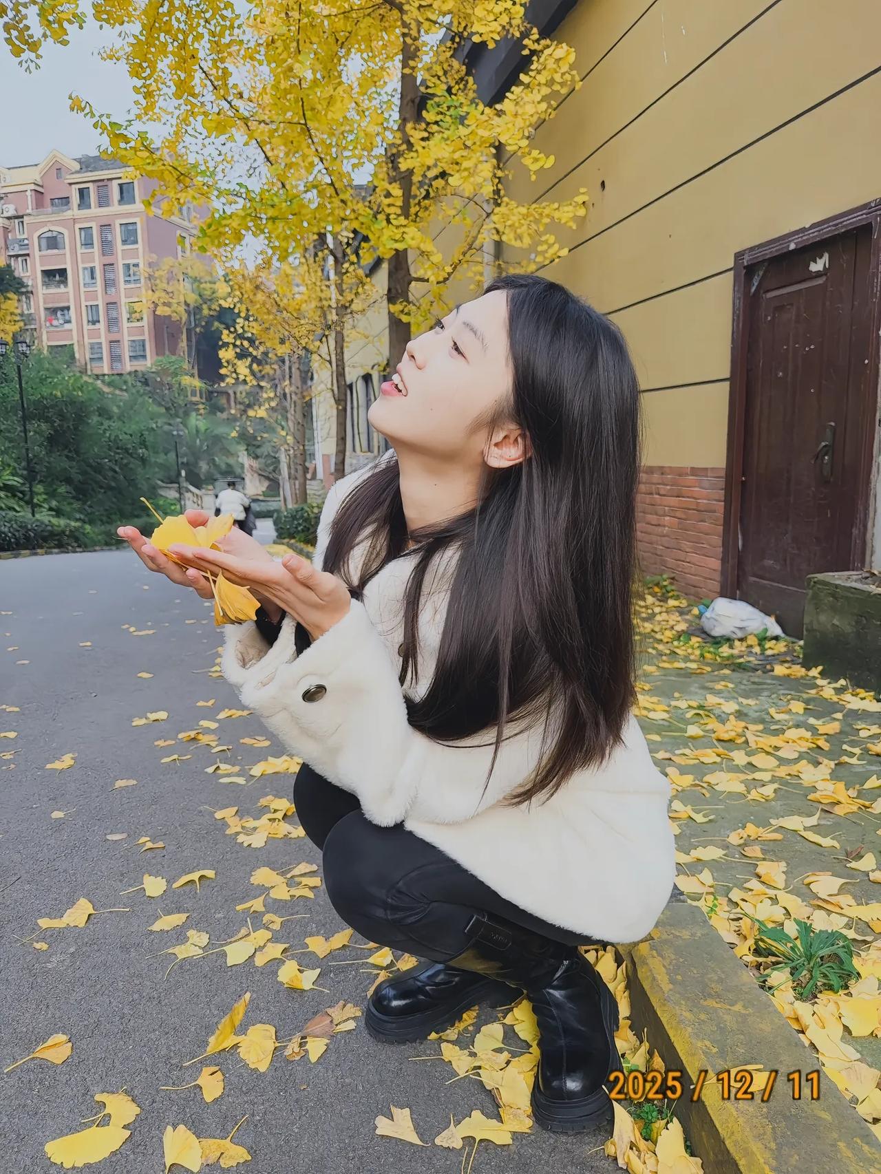 秋日暖阳下，落叶纷飞，少女轻抚落叶，感受大自然的美好。