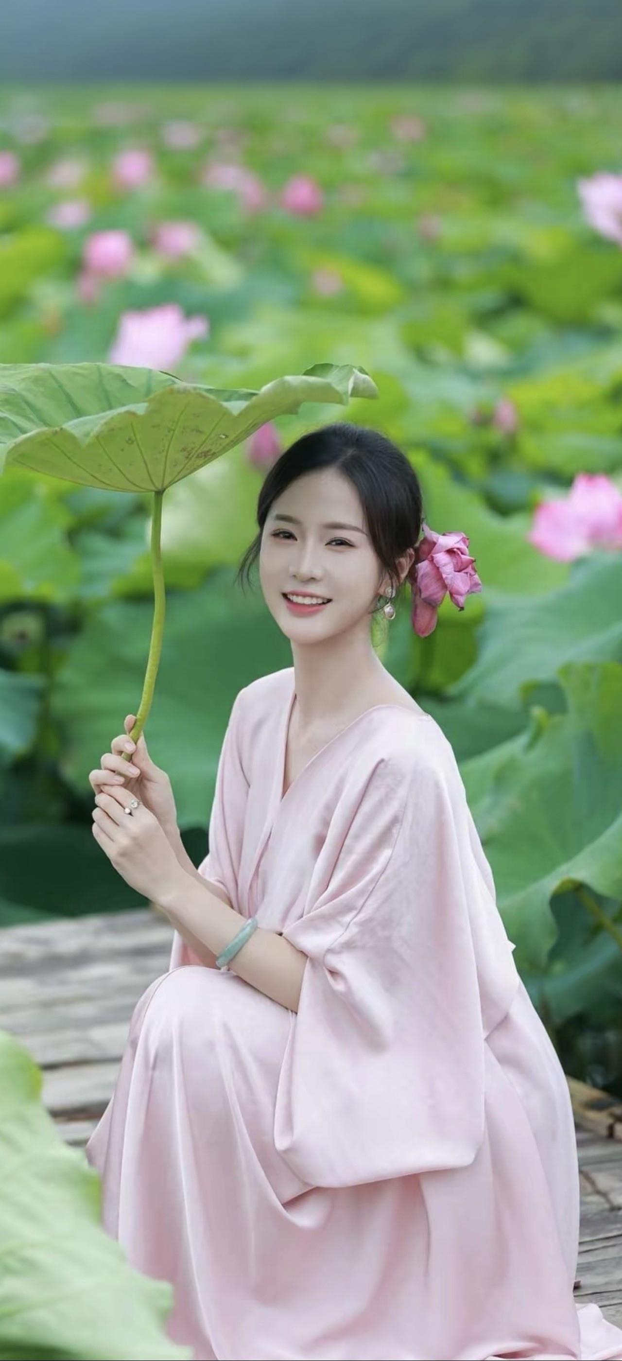 粉衣美人倚荷坐，笑语如花入画来。
