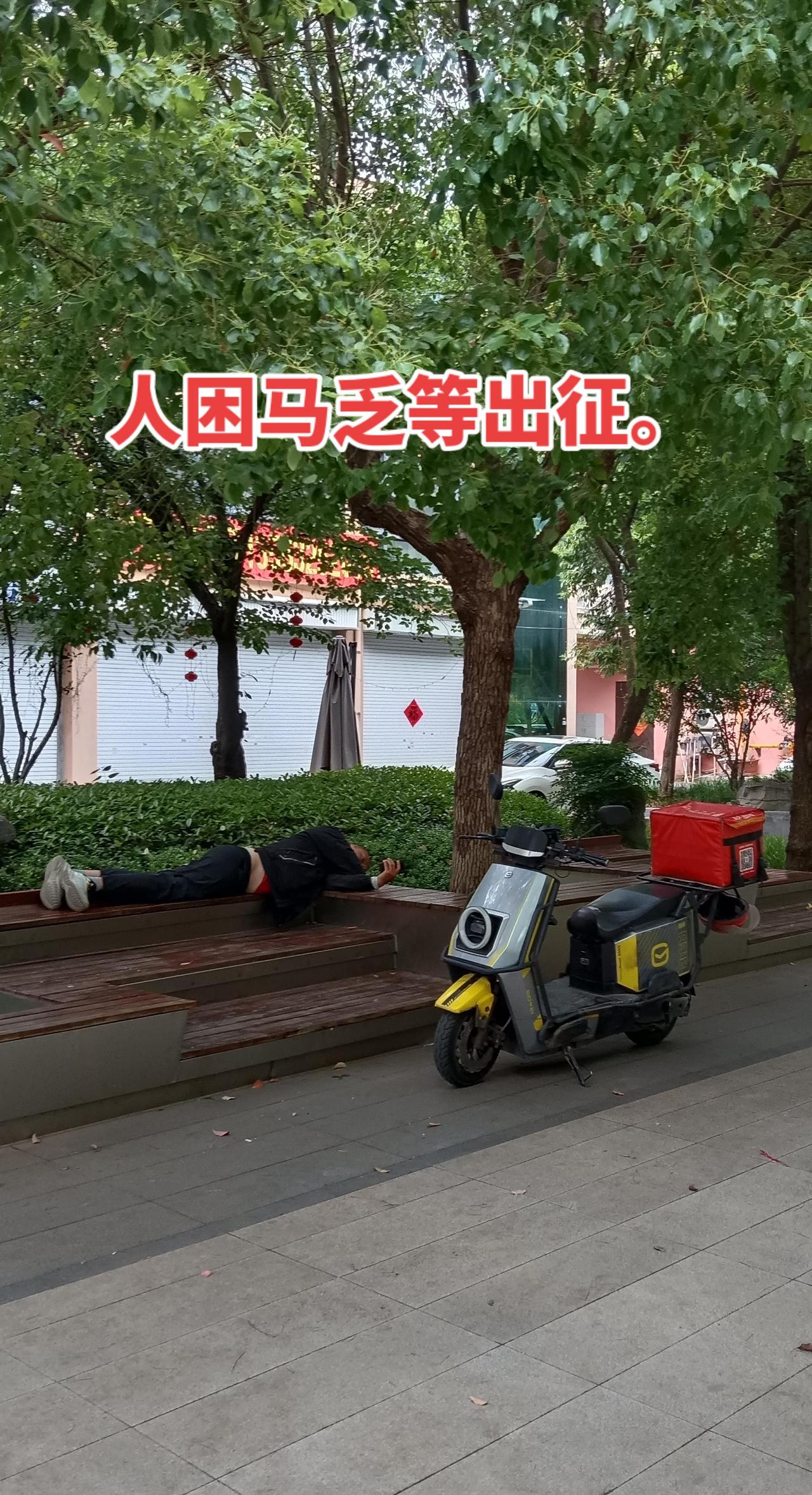滕州公园随拍，人困马乏等单中。滕州公园，一个外卖骑手在休息，刷刷手机，看看有没有
