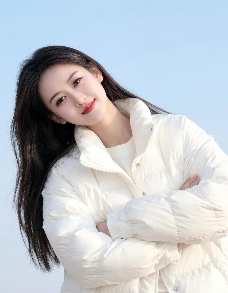 冬日暖阳下的温柔笑容，白色羽绒服的温暖守护。