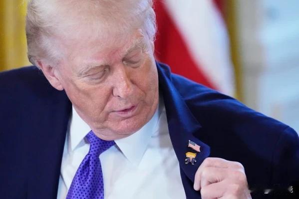 特朗普戴了一个新的“快乐特朗普”翻领别针，图案是特朗普卡通化的大脑袋和张大嘴巴的