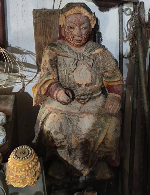 我爸收废品拉回一车旧家具，里头混着尊木头神像，坐着，身上漆裂得像龟纹、彩绘一片片
