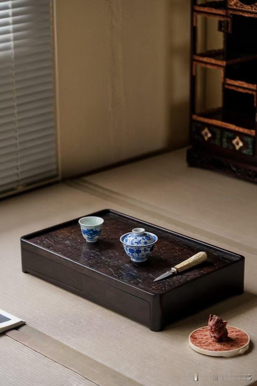 木色深沉，纹理却自有一番灵动。

一方器物，将茶席与文房巧妙相融。冰裂般的天然纹