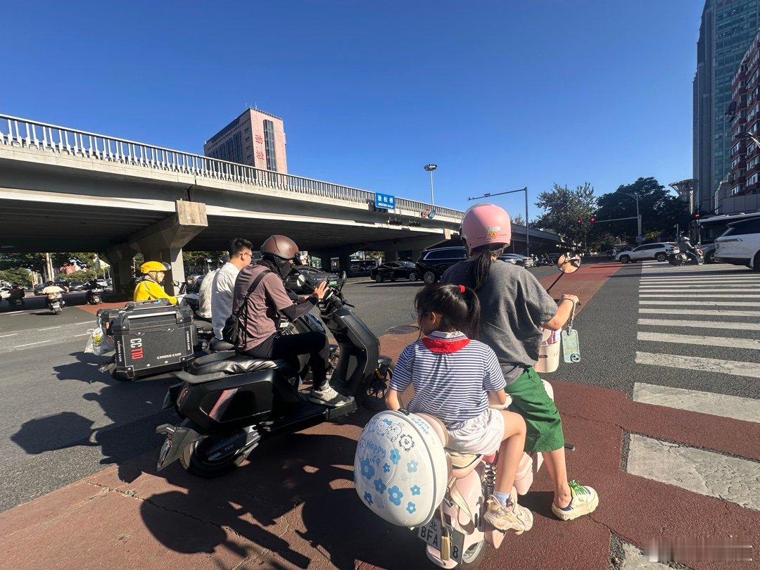 下午，北京，东三环劲松桥附近，这位家长带着小朋友骑电瓶车，家长戴了头盔，，小朋友