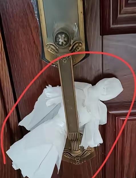 朋友发了一张照片给我，他说他下班之后回家，发现自己家的房门挂上了这么一个小人在这