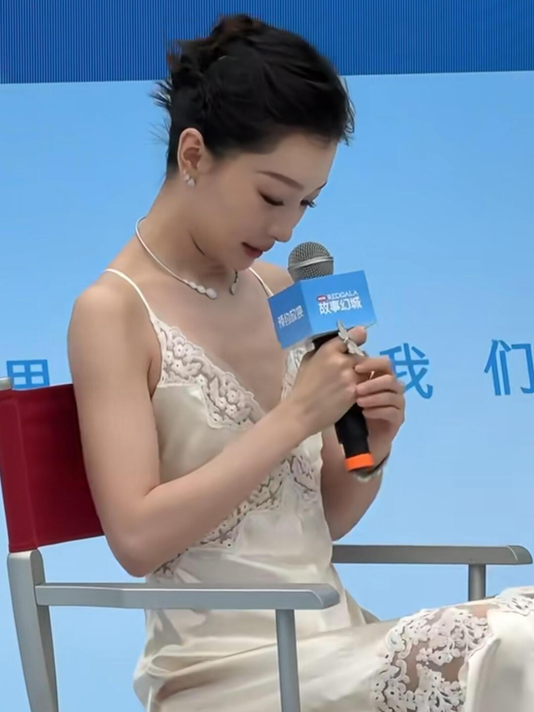 周冬雨这是在瞅啥？胸前一马平川，毫无沟壑。但肤白貌美，一袭镂空白色吊带裙，搭配着