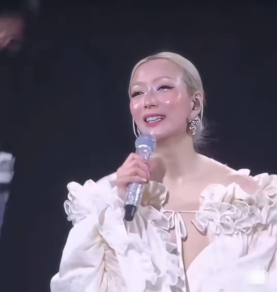 一个穿着漂亮礼服的人在唱歌。可以说是八零后的偶像，不仔细看，还真认不出来，有变化