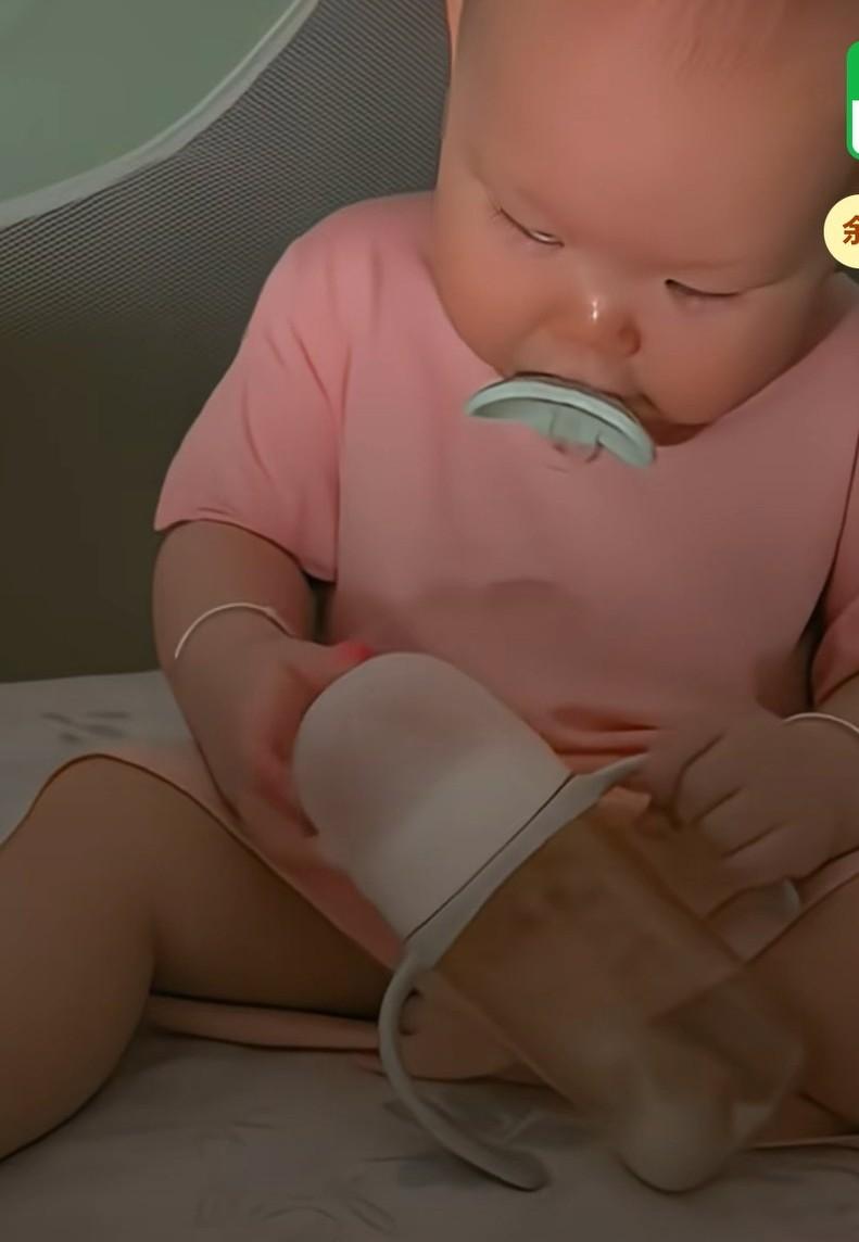 晚上宝宝喝完奶已经困的不行了，自己拿起安抚奶嘴叼在嘴里，
然后拿起奶瓶盖就自己往