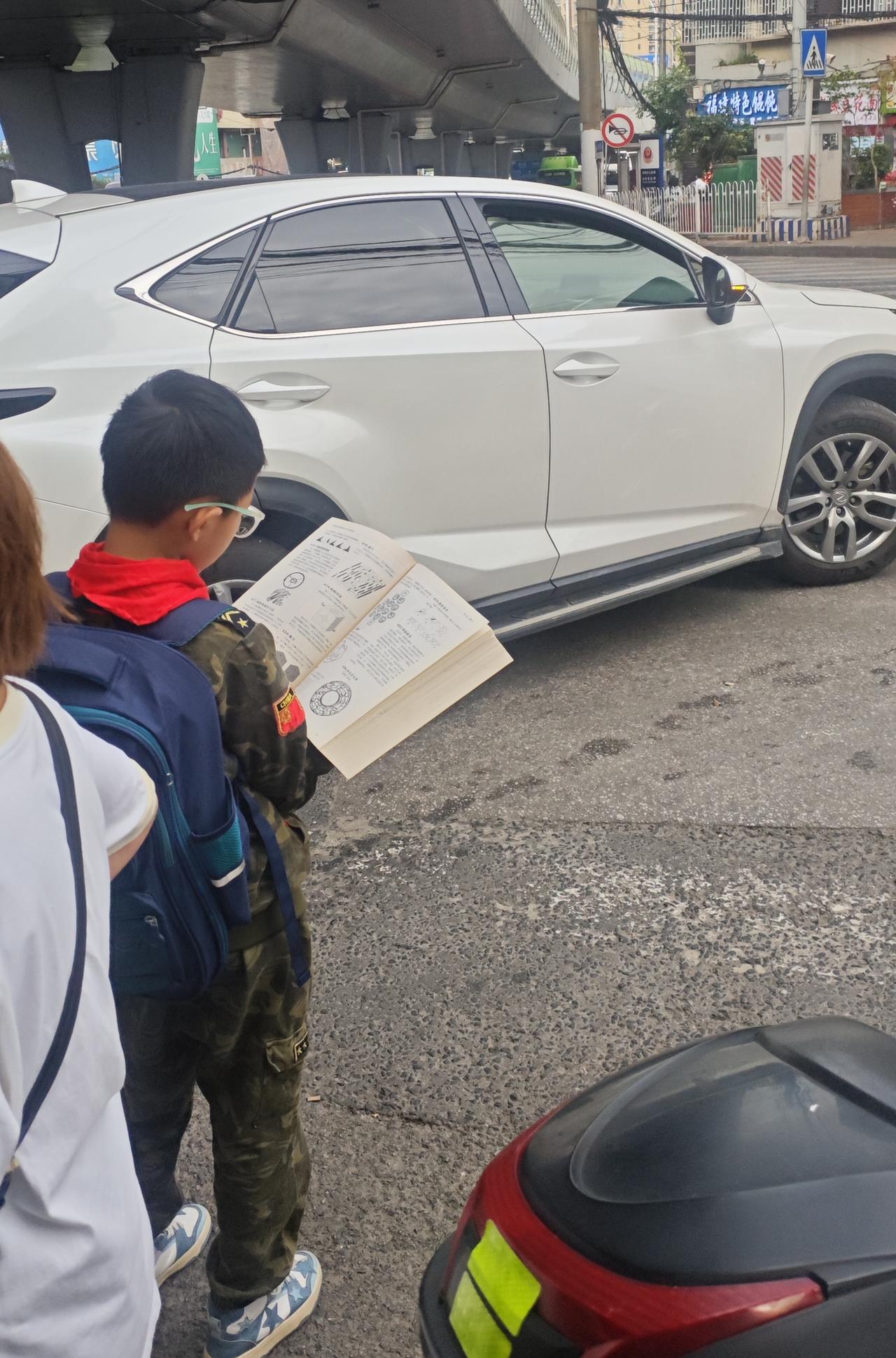 正在等红绿灯过马路时，被这小孩哥看的书吓了一跳，刚开始以为是小小年纪就研究如此深