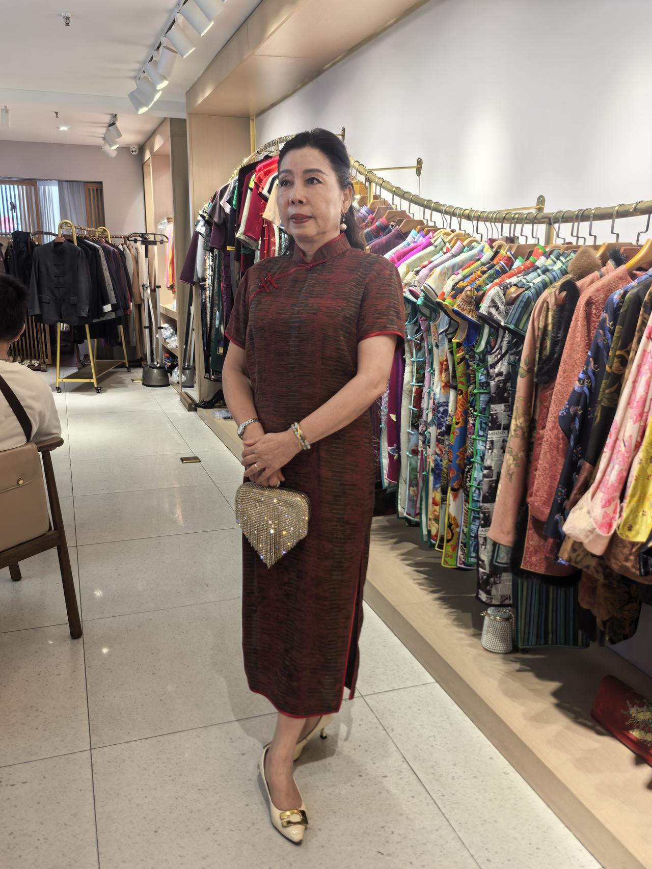 女士在店里挑选旗袍，很优雅。