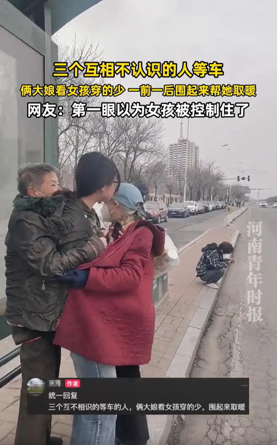 天津，一女孩在公交站等候公交，因为穿的太少，站在那里瑟瑟发抖，两位大妈见状，直接