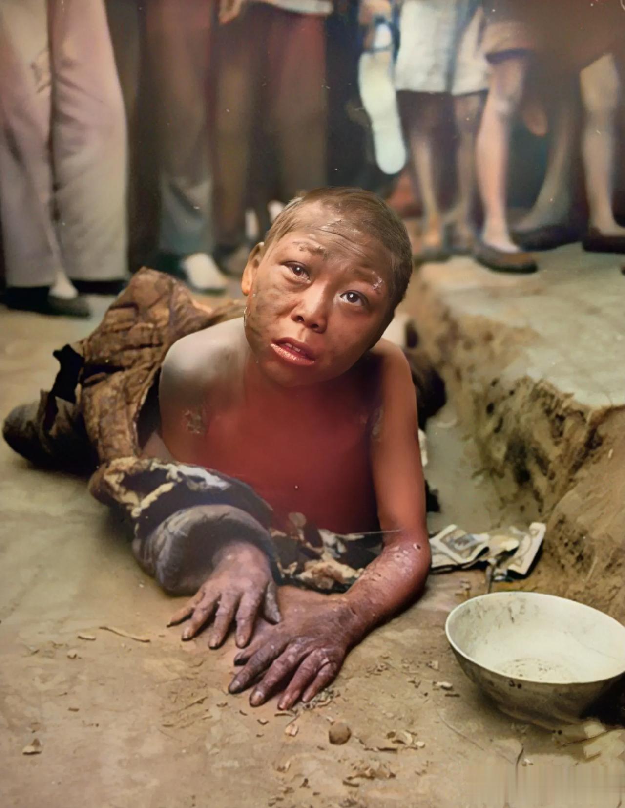 照片拍摄于1946年，湖南大饥荒时期，这是一个趴在地上行乞的小男孩，他衣不蔽体、