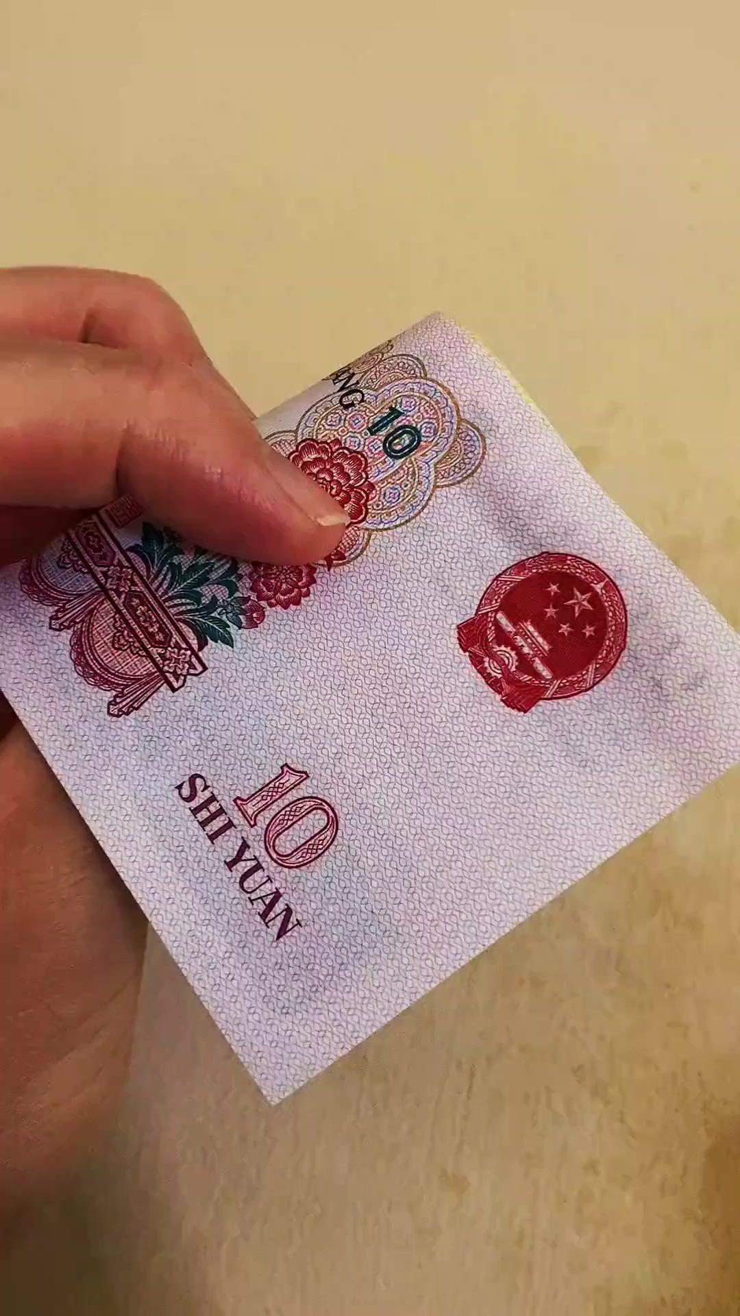 指尖抚过一张张泛黄的老版人民币，仿佛能触碰到逝去岁月的温度。
纸币上的每道折痕、