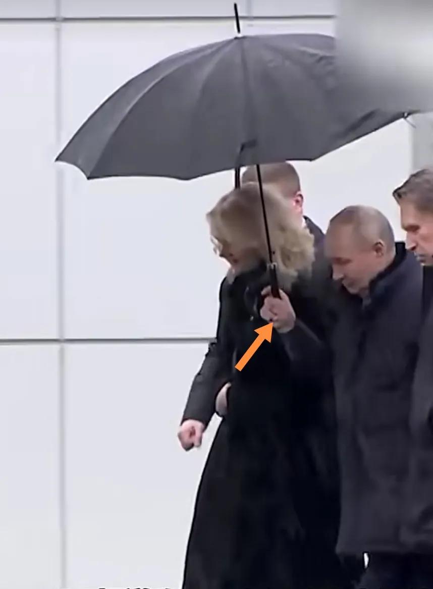 普京雨中给同事撑雨伞。