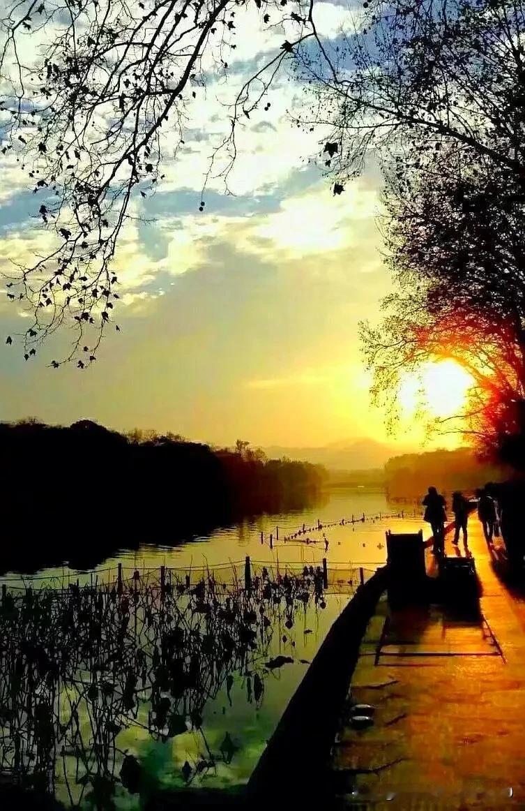 我有一张秋冬傍晚时分于西湖杨公堤用手机拍摄的湖面夕阳美景照片。
在照片里，天空被