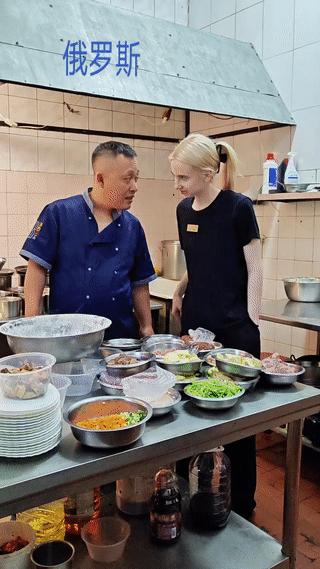 俄罗斯一家中餐厅饭店后厨。
一名中国厨师正在和一名俄罗斯女孩聊天说话。
由于这些