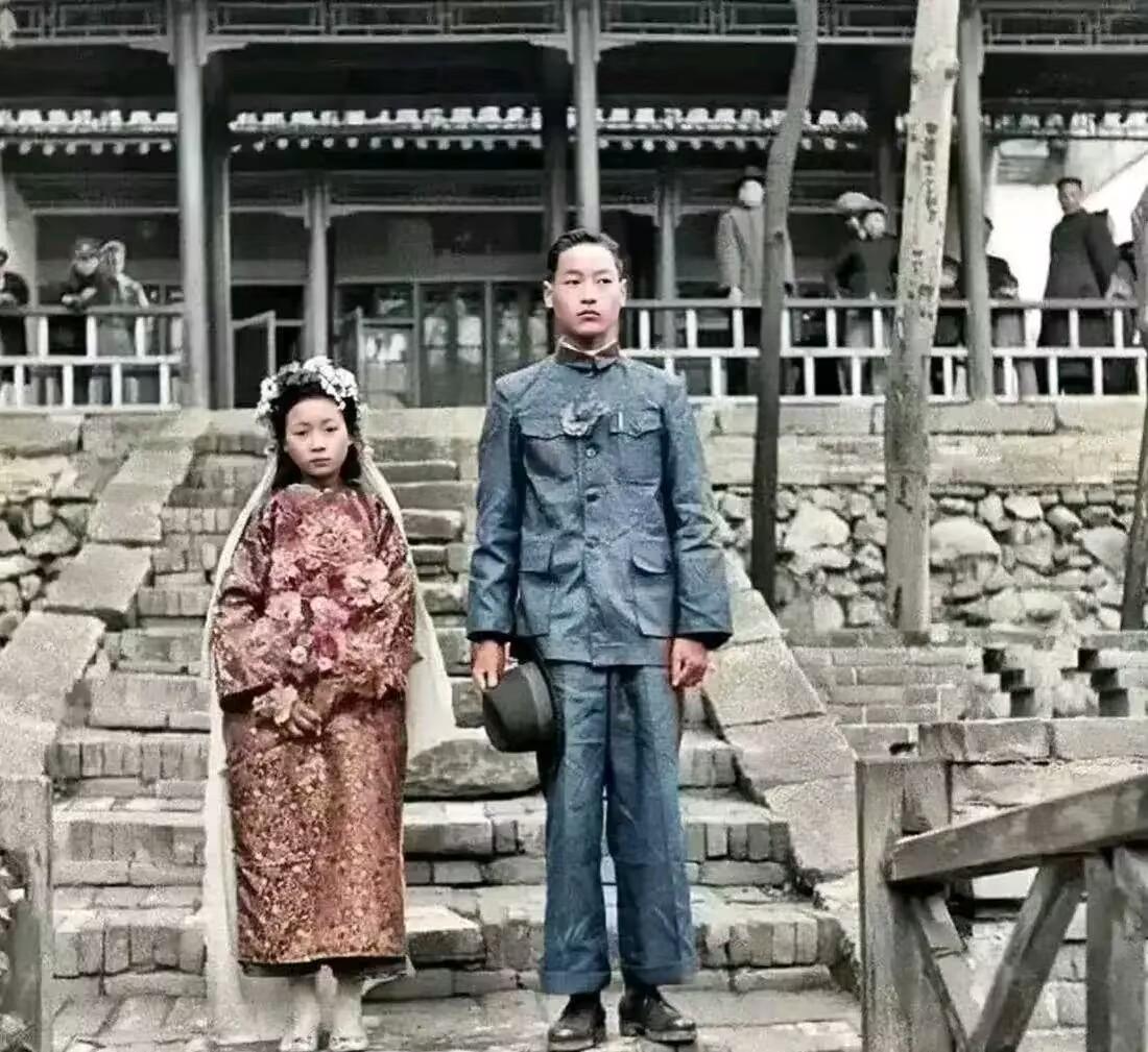 1936年，陕西临潼，一对小夫妻在众人的注视下，拍下了这张新婚合影照。

男孩穿