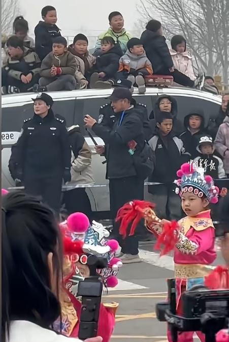 世界另一边是战火连天，东大这边是坐在警车顶上看演出的孩子，看护他们的民警与热烈的