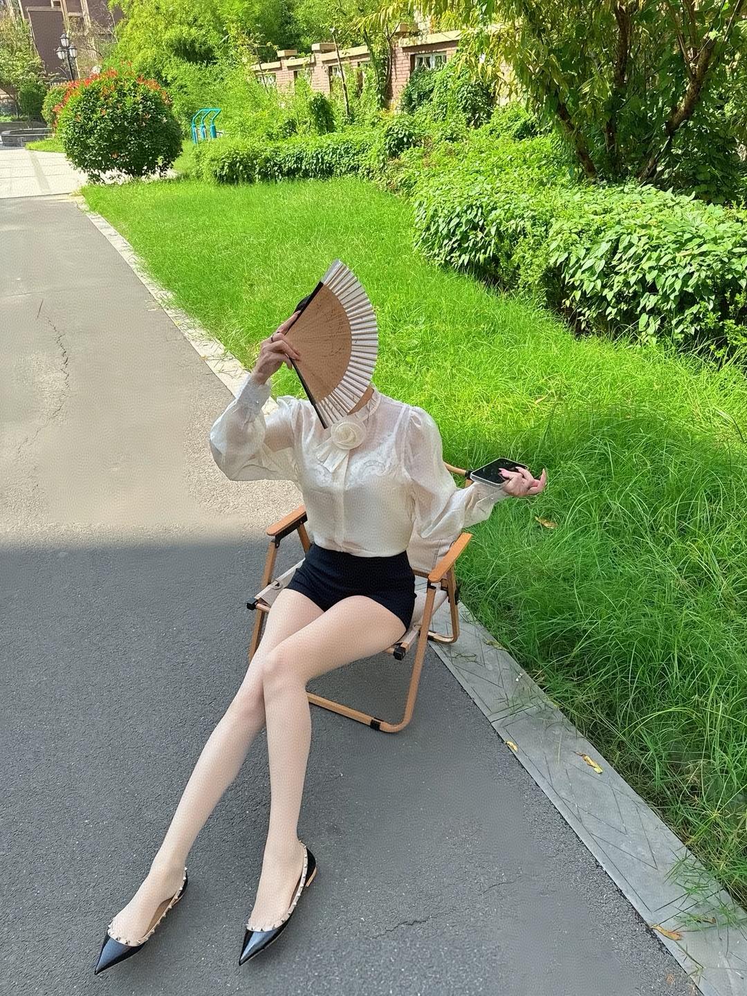 夏日午后，绿意盎然，优雅坐椅，手持折扇，享受宁静时光。