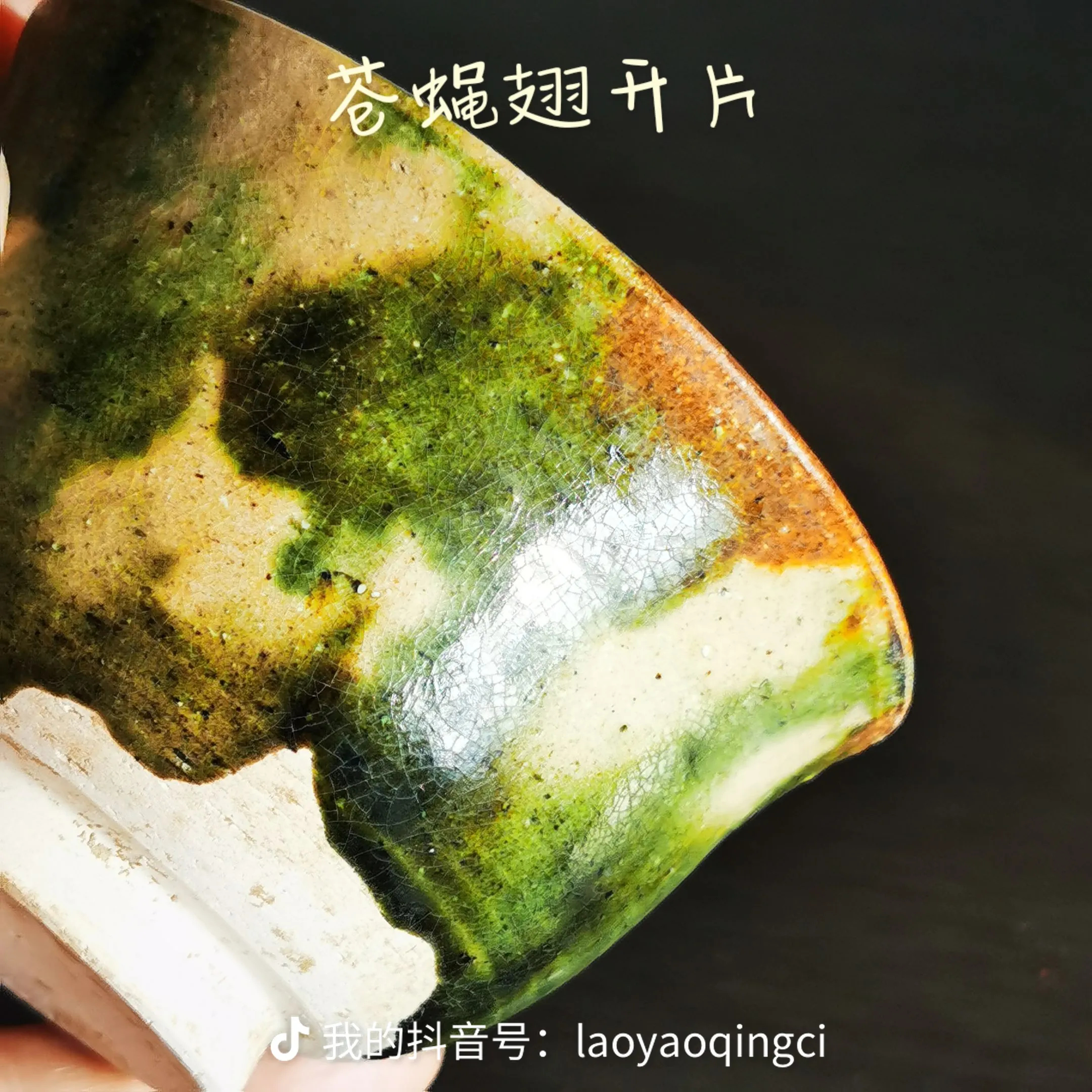 这件唐代三彩把杯，仿金银器造型，杯口为撇口，杯身呈筒状，底部有圈足，杯身一侧设有